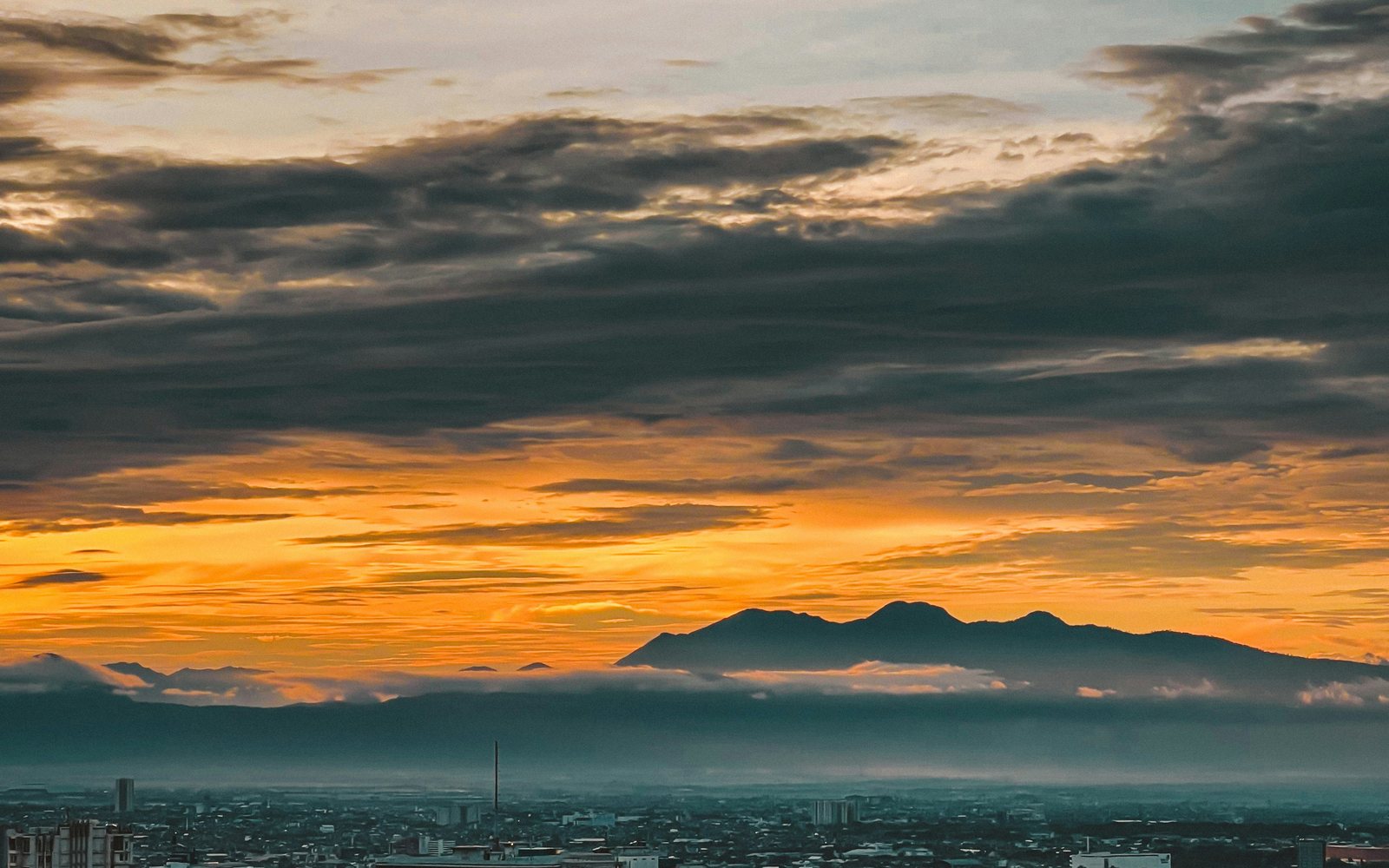 Sunrise over Bandung with mountains behind the city